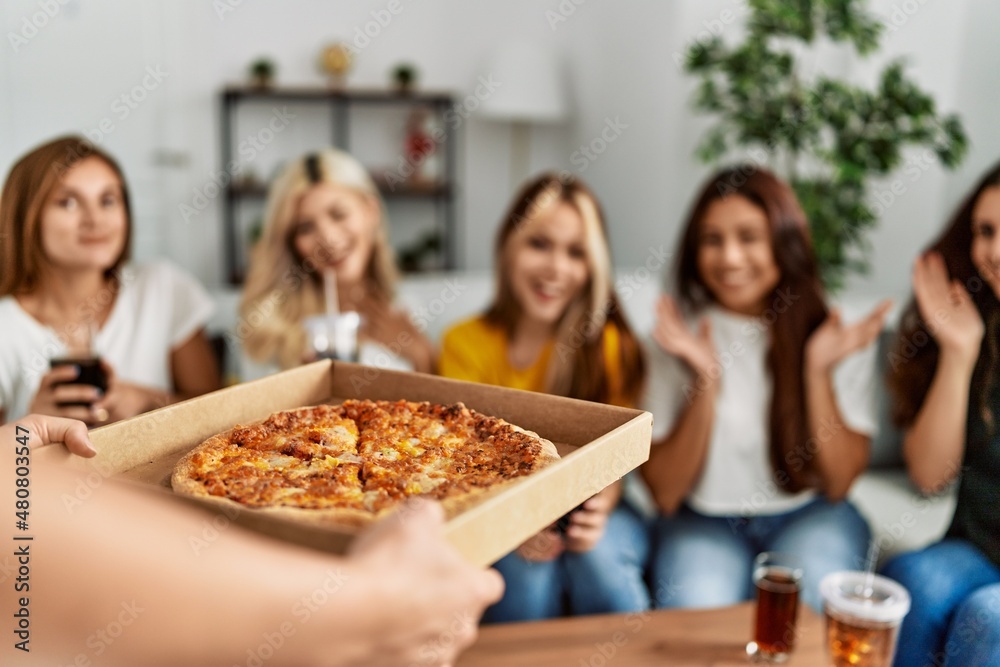 Group of young friends woman surprise for italian pizza sitting on the sofa at home.