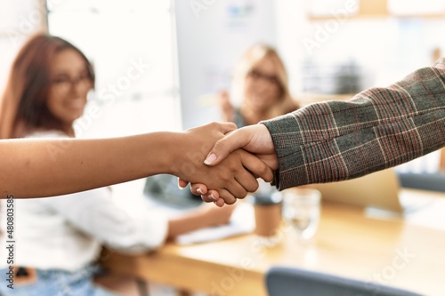 Group of young businesswoman looking partners handshake at the office.