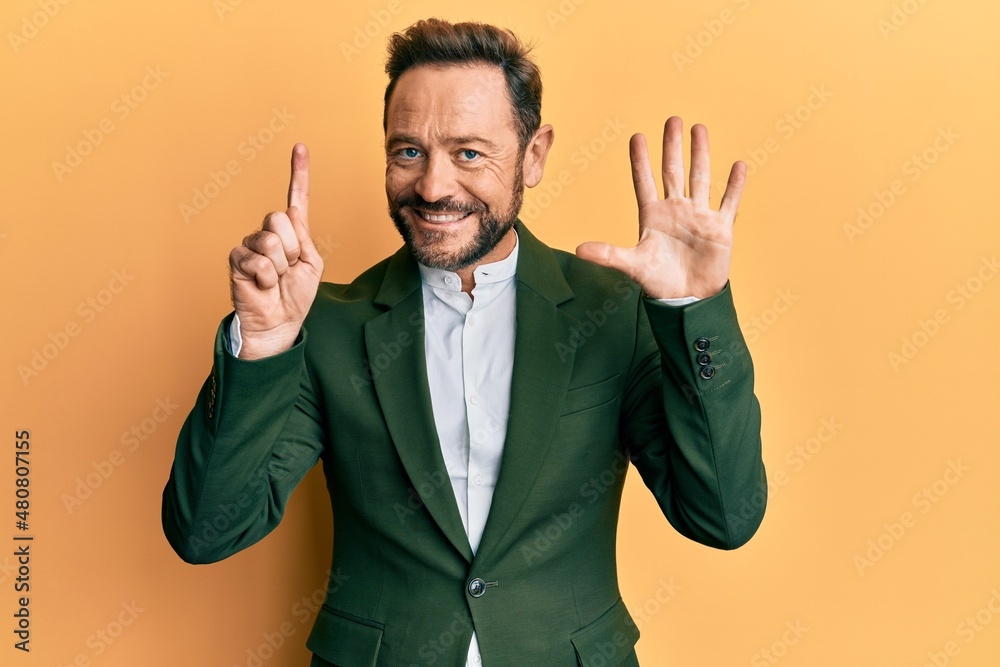 Middle age man wearing business suit showing and pointing up with fingers number six while smiling confident and happy.