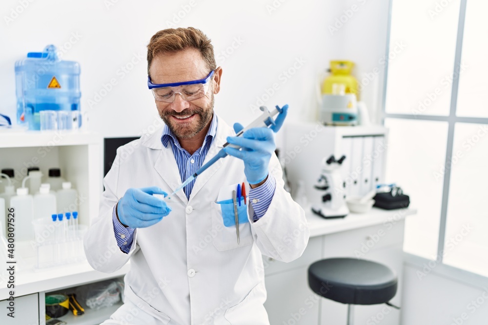 Middle age hispanic man wearing scientist uniform working at laboratory Middle age hispanic man wearing scientist uniform working at laboratory