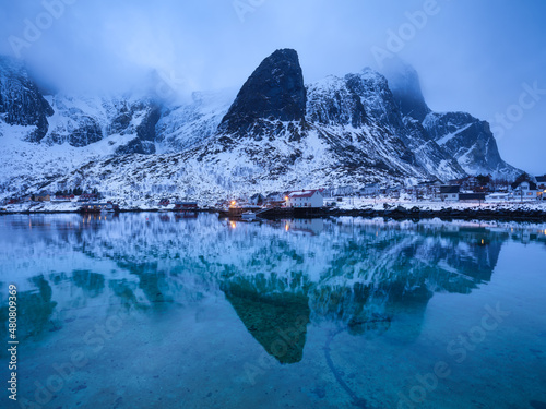 View on the house in the Lofoten Islands, Norway. Landscape in winter time during blue hour. Mountains and water. Travel image. photo