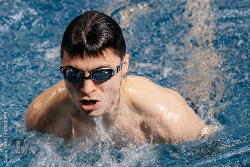 Professional swimmer competes in an indoor swimming pool race. Concept of competitions and motivation for sports