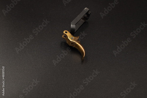 golden spare parts for a pistol on a black background © Сергей Луговский