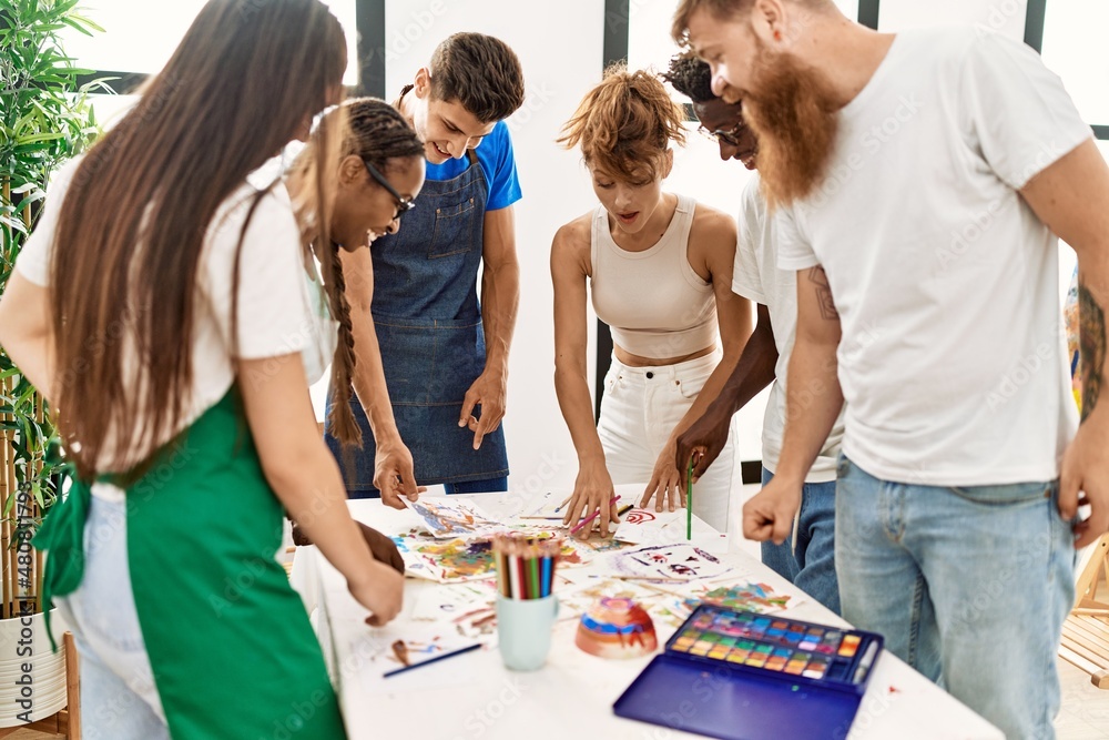 Group of people smiling happy drawing standing around the table at art studio. Group of people smiling happy drawing standing around the table at art studio.