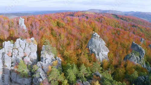 Aerial photo drone copter beautiful autumn beech forest and ancient rocks of Dovbush in Bubnishche Carpathians Ukraine, pagan temple and caves of a Christian monastery, tourist famous place photo