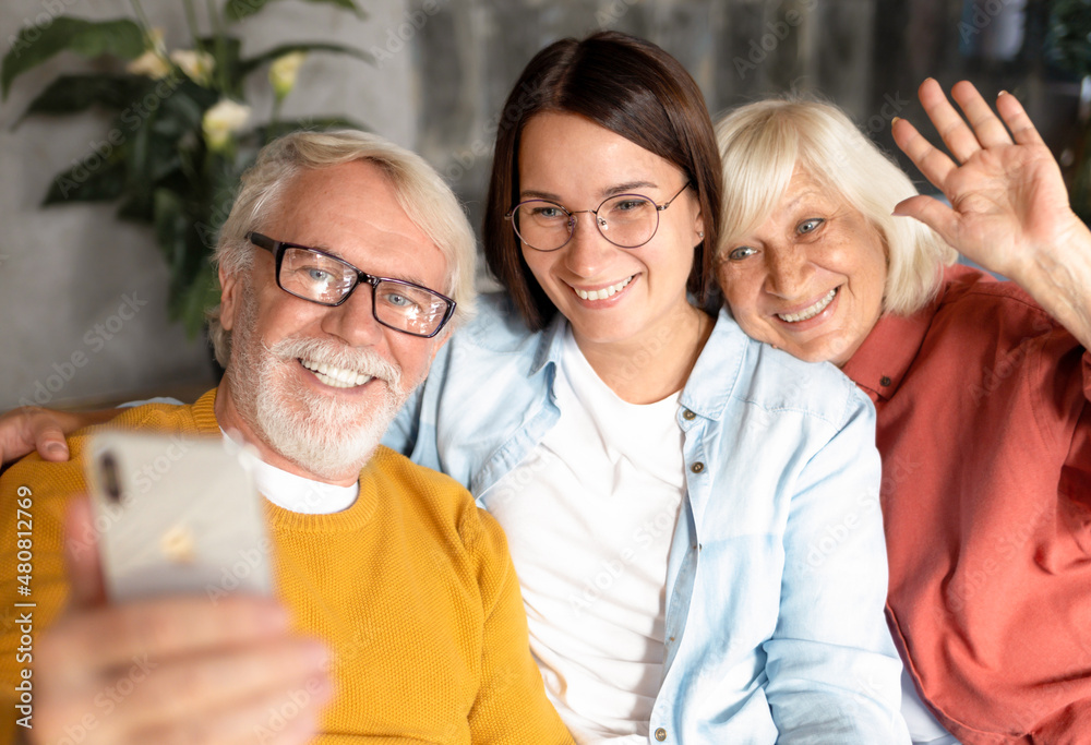 Two generation family happy elderly people with adult daughter happily take a selfie or talking to relatives via video call using a mobile phone Two generation family happy elderly people with adult daughter happily take a selfie or talking to relatives via video call using a mobile phone