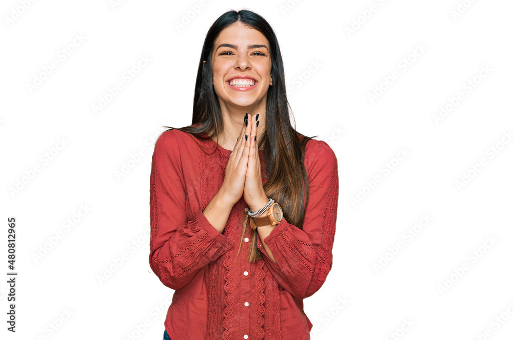 Young hispanic woman wearing casual clothes praying with hands together asking for forgiveness smiling confident.
