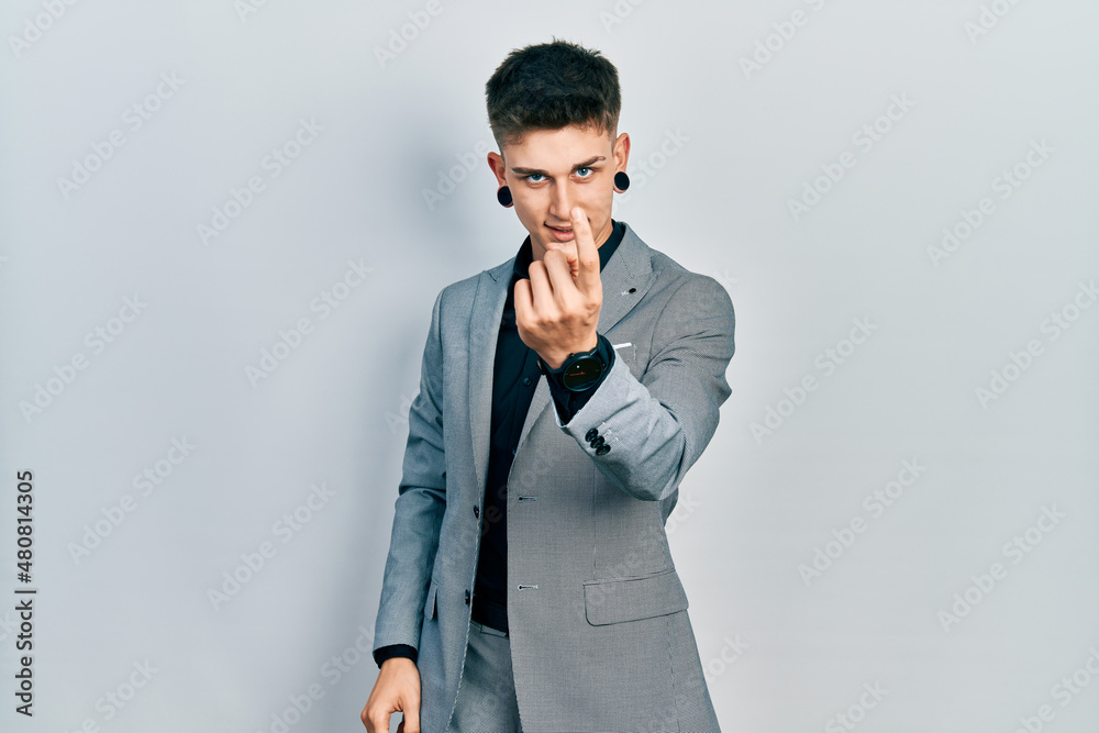 Young caucasian boy with ears dilation wearing business jacket beckoning come here gesture with hand inviting welcoming happy and smiling Young caucasian boy with ears dilation wearing business jacket beckoning come here gesture with hand inviting welcoming happy and smiling