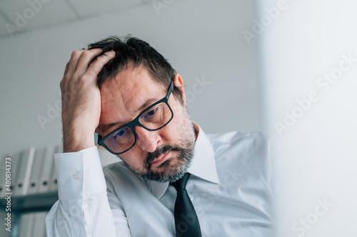 Photo Regretting bad business decision, disappointed businessman in office