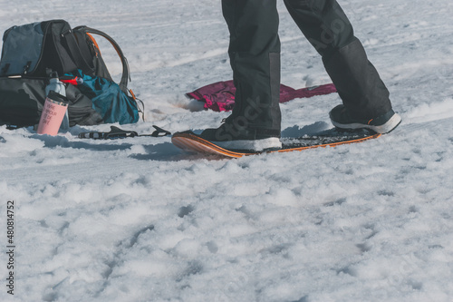 A close-up shot of a Caucasian man sliding down a slope on a snow skate at a ski resort in France photo