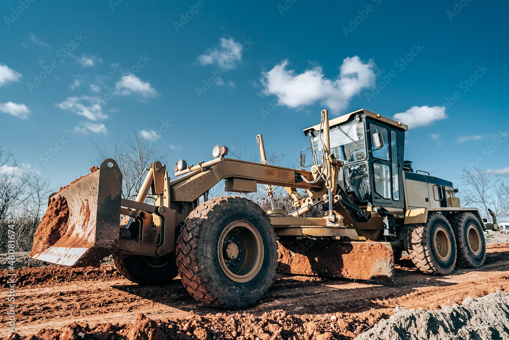 Road grader smoothing gravel surface for new road. Scraper leveling ground, working at construction. Earthmoving, excavations, digging on soils. Road grader smoothing gravel surface for new road. Scraper leveling ground, working at construction. Earthmoving, excavations, digging on soils.