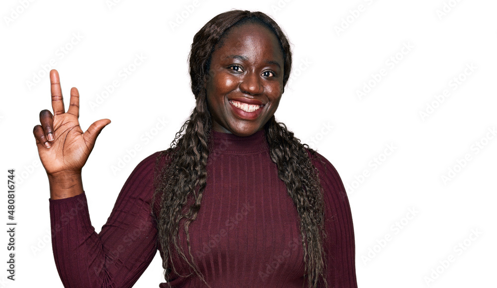 Young african woman wearing casual winter sweater showing and pointing up with fingers number three while smiling confident and happy. Young african woman wearing casual winter sweater showing and pointing up with fingers number three while smiling confident and happy.