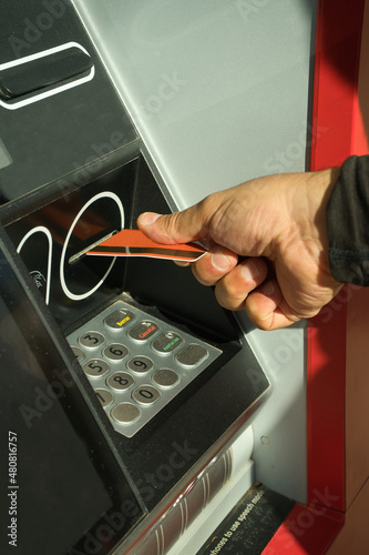 Man using ATM and making financial operations.