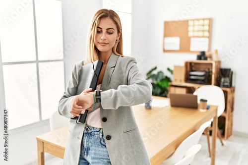 Canvas Print Blonde business woman at the office checking the time on wrist watch, relaxed an