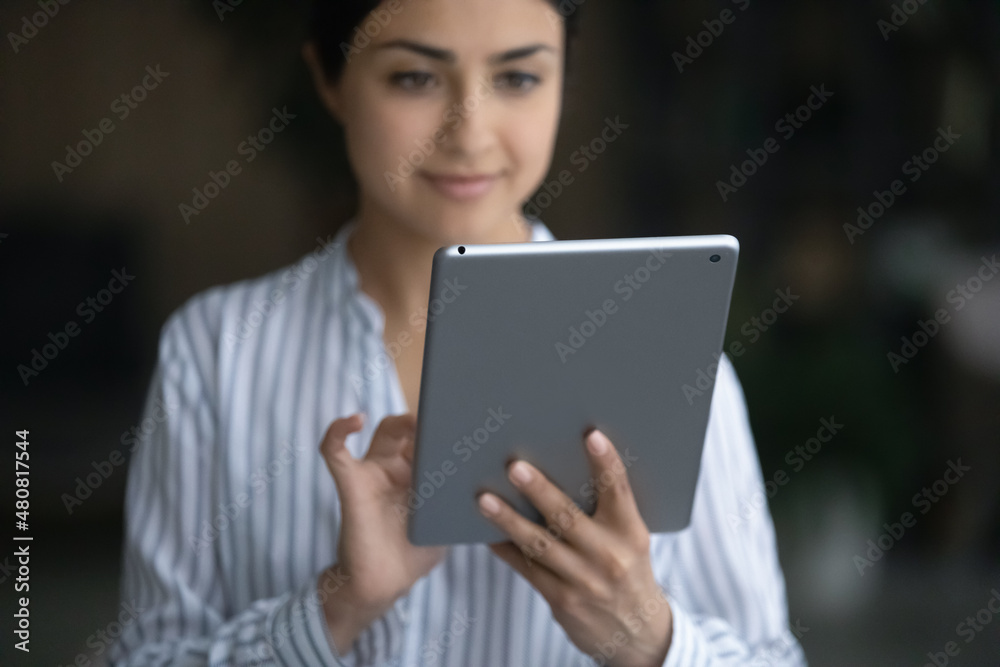 Close up focus on digital computer table in female hands, happy Indian ethic woman web surfing information online on touchpad gadget, playing games, planning meeting or communicating distantly. Close up focus on digital computer table in female hands, happy Indian ethic woman web surfing information online on touchpad gadget, playing games, planning meeting or communicating distantly.