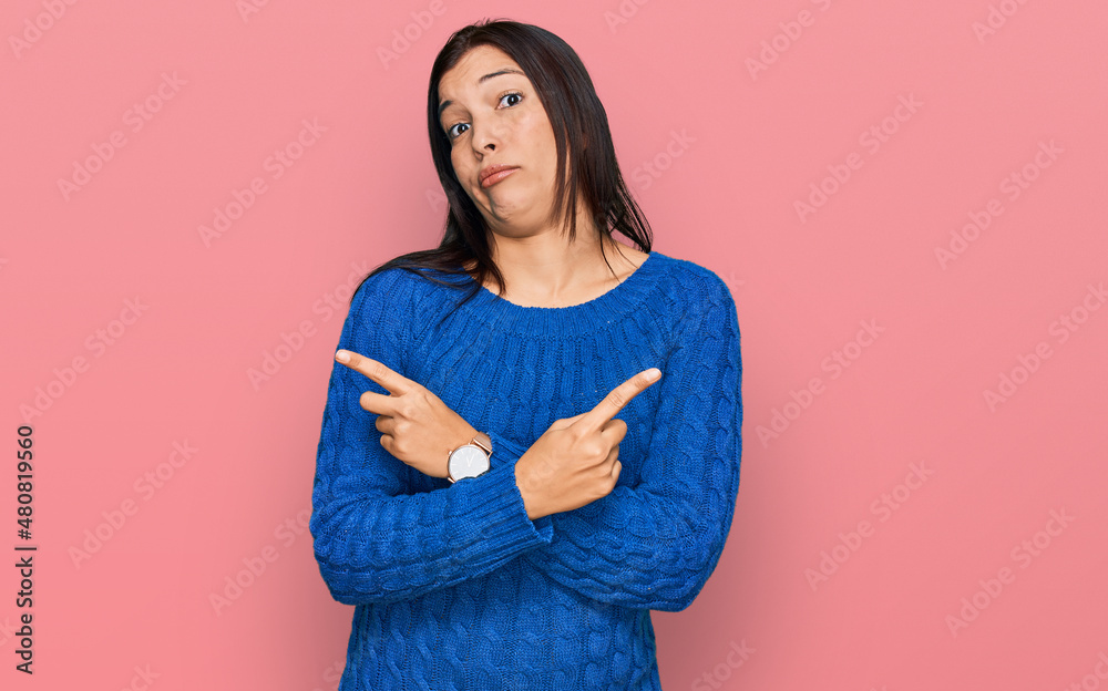 Young hispanic woman wearing casual clothes pointing to both sides with fingers, different direction disagree Young hispanic woman wearing casual clothes pointing to both sides with fingers, different direction disagree