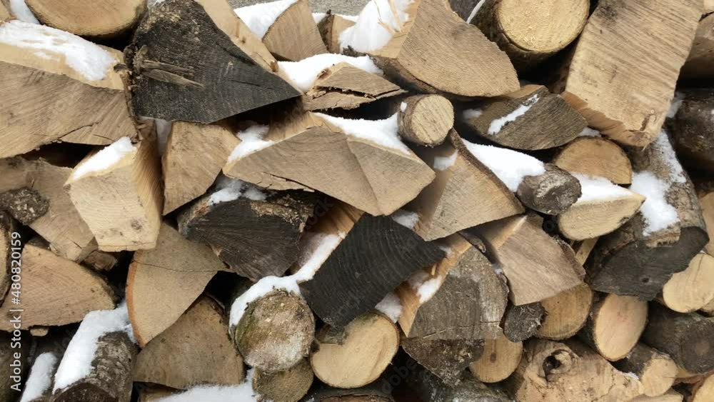 Sawn and chipped wood stacked side by side against the wall. Storing firewood for the winter. High quality 4k footage Sawn and chipped wood stacked side by side against the wall. Storing firewood for the winter. High quality 4k footage