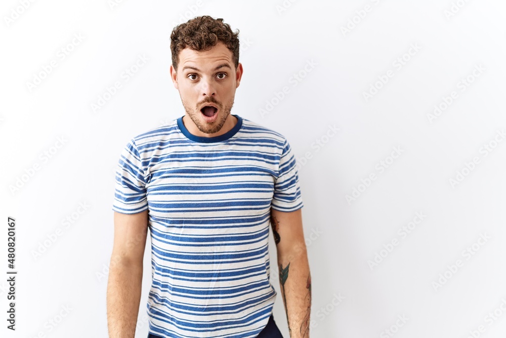 Handsome young man standing over isolated background afraid and shocked with surprise and amazed expression, fear and excited face. Handsome young man standing over isolated background afraid and shocked with surprise and amazed expression, fear and excited face.