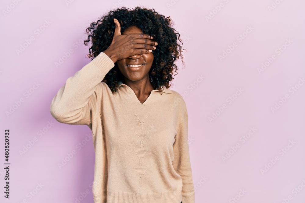 Young african american woman wearing casual clothes smiling and laughing with hand on face covering eyes for surprise. blind concept. Young african american woman wearing casual clothes smiling and laughing with hand on face covering eyes for surprise. blind concept.