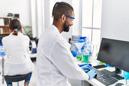 Man and woman scientist partners smiling confident working at laboratory