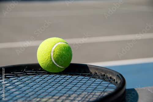 tennis ball on black racquet, on hard court © Claudia Luna