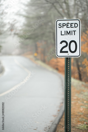 speed limit 20 sign on road in the fog