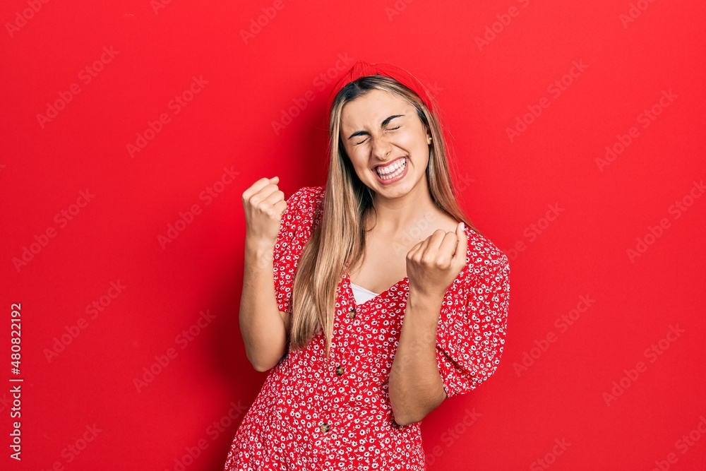 Beautiful hispanic woman wearing summer dress excited for success with arms raised and eyes closed celebrating victory smiling. winner concept. Beautiful hispanic woman wearing summer dress excited for success with arms raised and eyes closed celebrating victory smiling. winner concept.