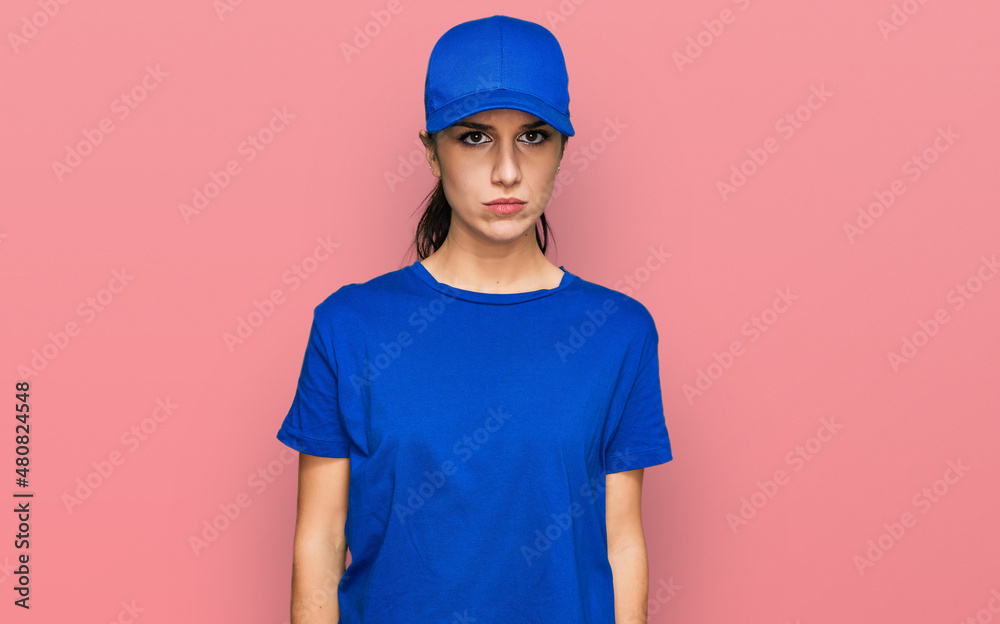 Young hispanic girl wearing delivery courier uniform depressed and worry for distress, crying angry and afraid. sad expression.