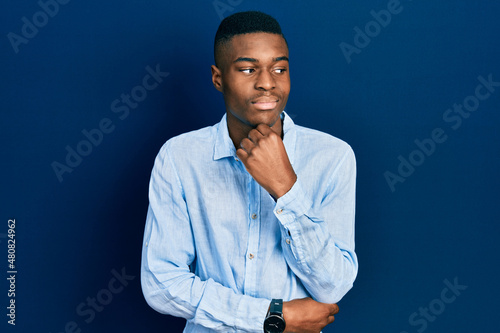 Young african american man wearing casual clothes with hand on chin thinking about question, pensive expression. smiling with thoughtful face. doubt concept.