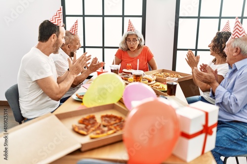 Group of middle age friends smiling happy celebrate birthday at home. © Krakenimages.com