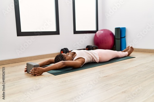 Young african american woman stretching at sport center