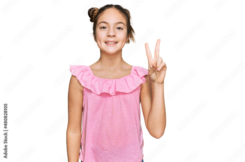 Beautiful brunette little girl wearing summer pink shirt smiling with happy face winking at the camera doing victory sign. number two. Beautiful brunette little girl wearing summer pink shirt smiling with happy face winking at the camera doing victory sign. number two.