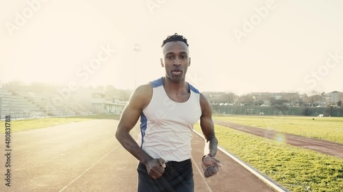 Male athlete run on running track in a stadium - Slow motion video of runner training outdoors - Sport concept