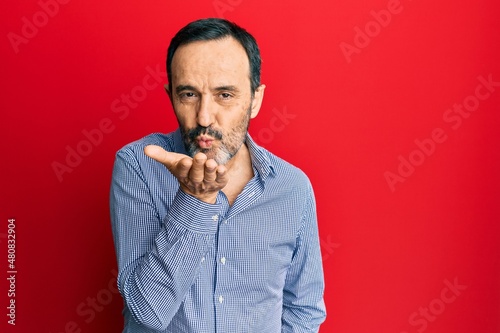 Middle age hispanic man wearing casual clothes looking at the camera blowing a kiss with hand on air being lovely and sexy. love expression. © Krakenimages.com
