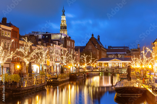 Night Leiden canal Oude Rijn, City Hall and bridge Koornbrug in Christmas illumination, South Holland, Netherlands.