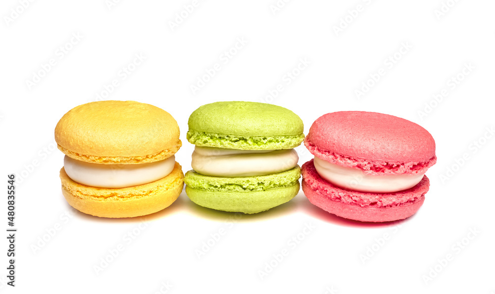 Banner of colorful macaroons isolated on white background. Lemon yellow, strawberry pink and green french cookies. Caramel hazelnut and strawberry cakes in front view. Bakery concept with blank space Banner of colorful macaroons isolated on white background. Lemon yellow, strawberry pink and green french cookies. Caramel hazelnut and strawberry cakes in front view. Bakery concept with blank space