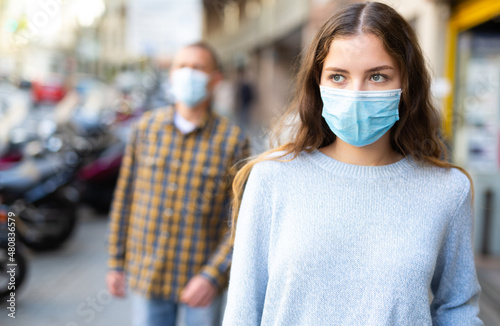 Portrait of young confident woman in protective face mask posing on the street
