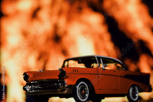 Retro car toy model in front of the fire background