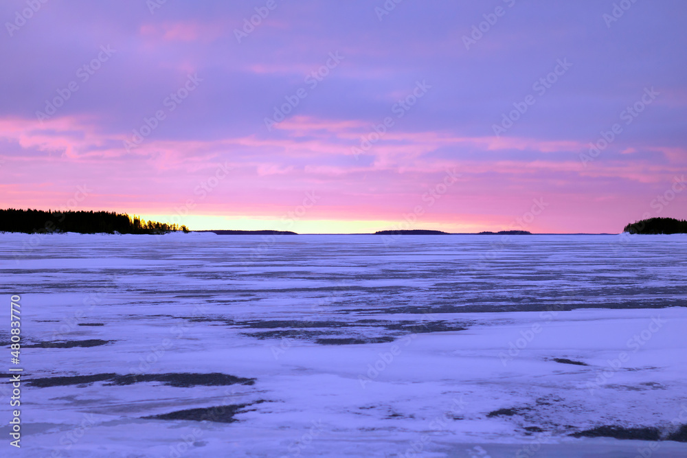 Winter landscape Lake Ladoga, a lot of ice with a fiery sunset or dawn sky. Karelia.