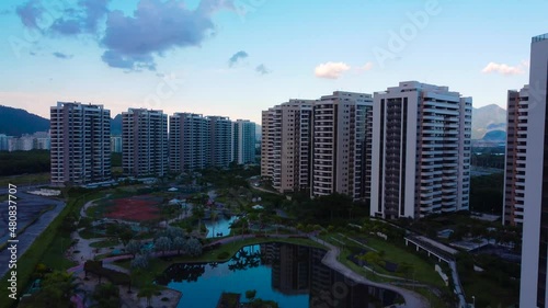 Aerial view of Ilha Pura Park at sunset with birds flying. In the background, the hills of Rio de Janeiro, Brazil and the Jacarépagua lagoon. Sunny Day and some clouds. Drone take. photo