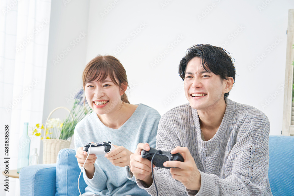 テレビゲームで遊ぶカップル テレビゲームで遊ぶカップル