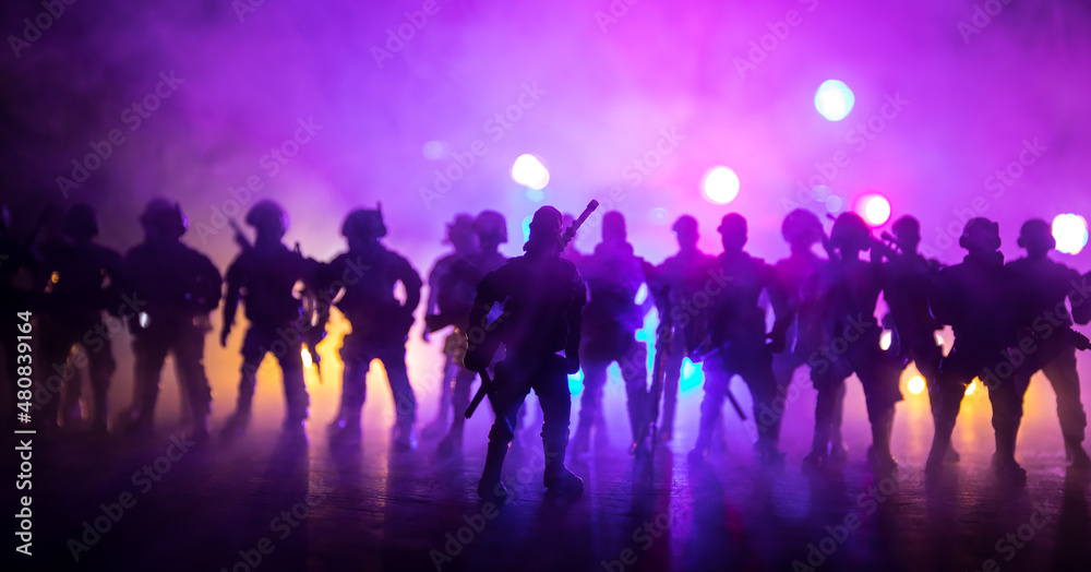 Anti-riot police give signal to be ready. Government power concept. Police in action. Smoke on a dark background with lights. Blue red flashing sirens. Dictatorship power Anti-riot police give signal to be ready. Government power concept. Police in action. Smoke on a dark background with lights. Blue red flashing sirens. Dictatorship power