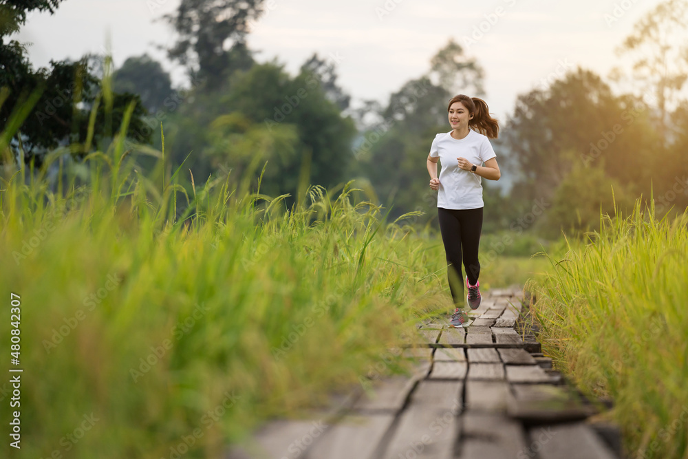 woman running on wooden path in field woman running on wooden path in field