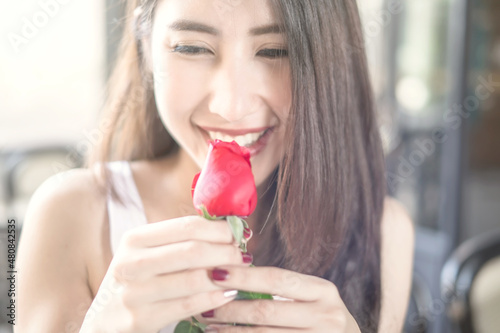 Beautiful Asian girl holding red rose with happiness smile in her wonderful Valentine s Day 