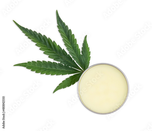 Marijuana Cannabis Hemp Plant Leaf next to a container of salve or balm Isolated On White Background