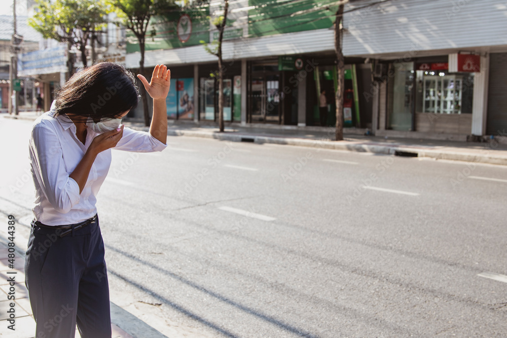 Woman wearing a mask, walking, outdoor places in the city full of dust. PM 2.5 and Coronavirus (COVID-19) because she wants to prevent and avoid spreading for her own health : Copy Space