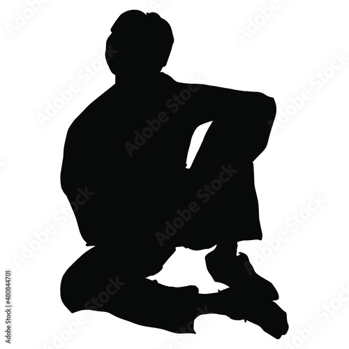 Seated young man in casual pose. Black silhouette on white background.