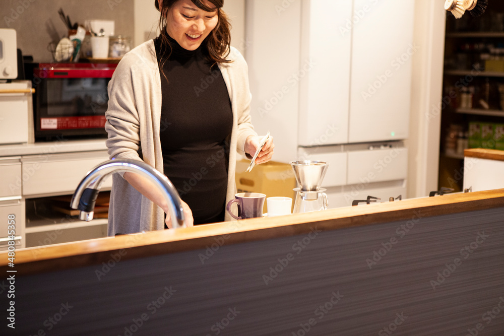 Obraz premium コーヒーを淹れる、妊娠している女性