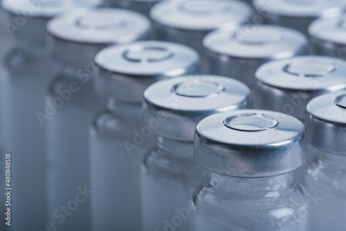Glass medical ampoule vial for injection. Medicine is dry white drug penicillin powder or liquid with of aqueous solution in ampulla. Close up.