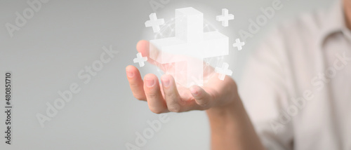 Hand holding plus sign virtual means to offer positive thing (like benefits, personal development, health insurance).Medical care concept. Hand holding  a medical care symbol. photo